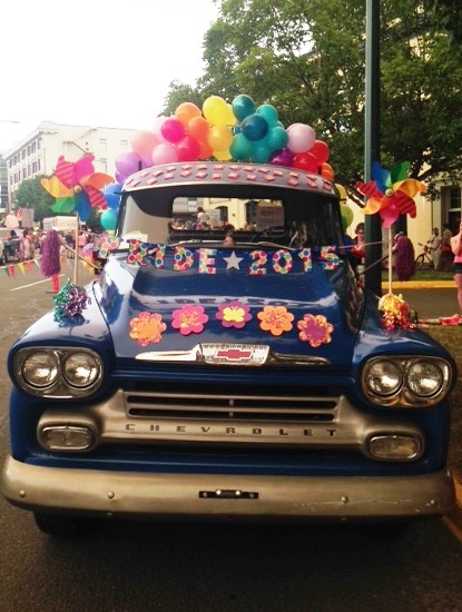 Vintage truck with rainbow balloon arch and streamers