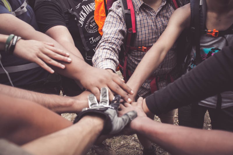 A group of diverse individuals join hands for community support