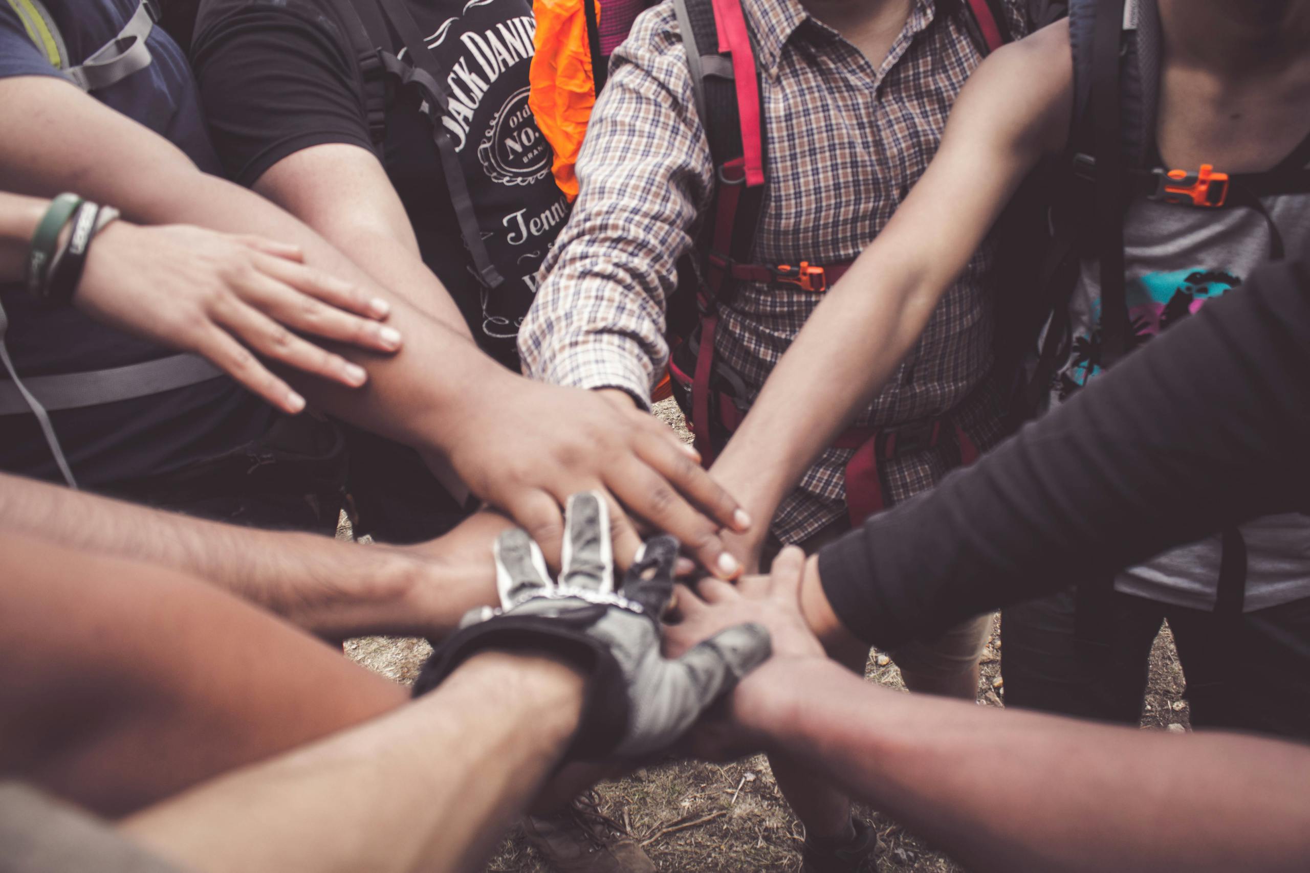 A group of diverse individuals join hands for community support